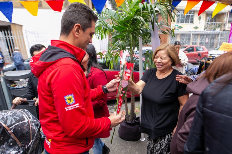 Foto de alcalde Local de Los Mártires entregando Flores en el día de las Madres